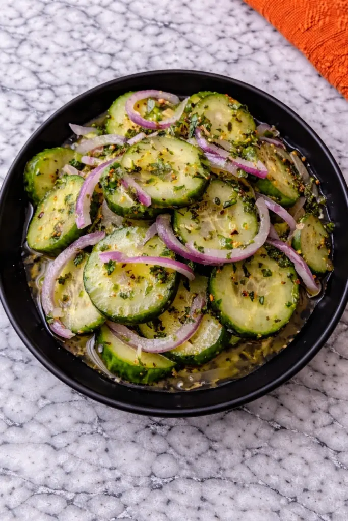 Italian Cucumber Salad with Red Onion in Black Bowl