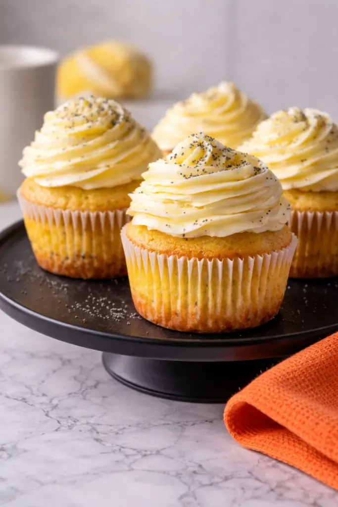 Lemon Poppy Seed Cupcakes with creamy lemon frosting on black cake stand