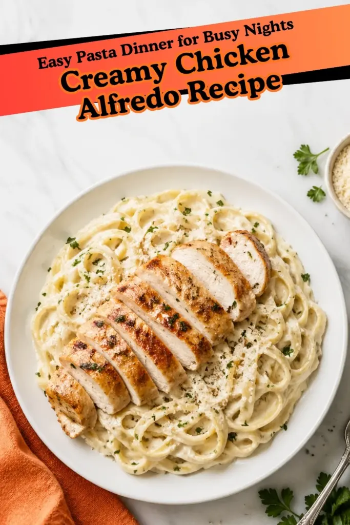 Chicken Alfredo Recipe with creamy fettuccine, sliced golden chicken, parmesan, and parsley on a white plate.