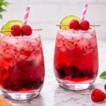 Refreshing red wine spritzer with raspberries lime and ice in glass