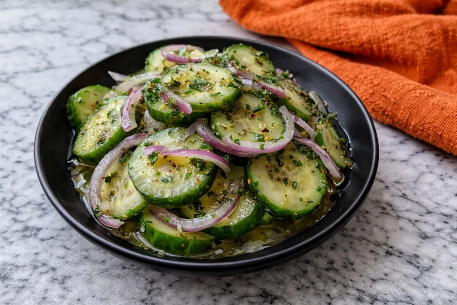 Italian Cucumber Salad in Black Bowl on Marble Countertop