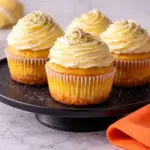 Lemon Poppy Seed Cupcakes with creamy frosting on black plate marble countertop