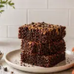 Cottage cheese brownie recipe stacked on a plate with chocolate chips