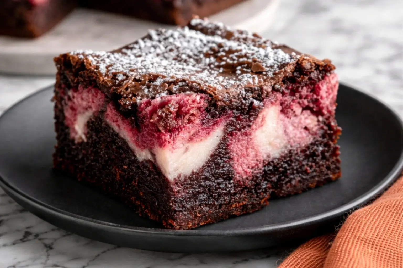 Fudgy Strawberry Swirl Brownies with Cream Cheese on Black Plate