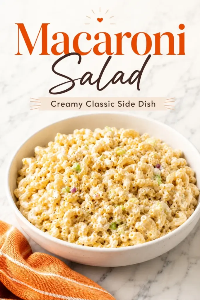 Pinterest-style image of creamy macaroni salad in a white bowl with orange towel and bold text reading Macaroni Salad, creamy classic side dish.