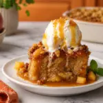Peach Sticky Pudding with vanilla ice cream, caramel sauce, fresh peaches, and mint on a white plate